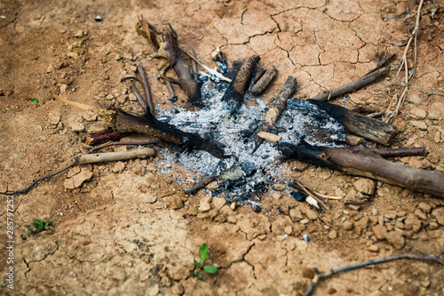 The ashes of a burned bonfire on cracked ground