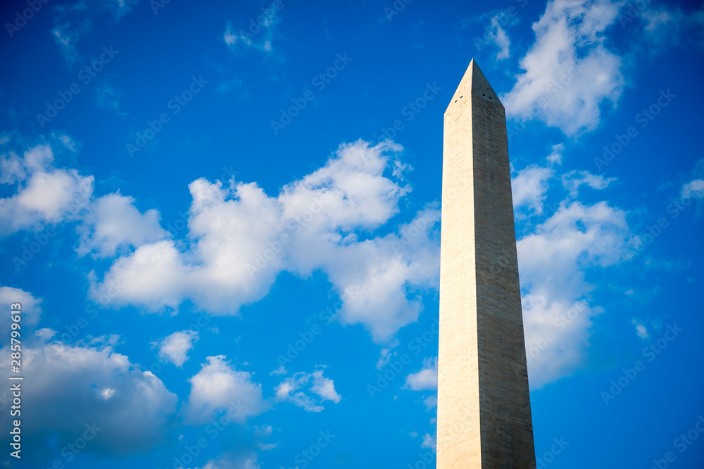 Scenic blue sky close-up of the Washington Monument with bright summer clouds in Washington DC, USA