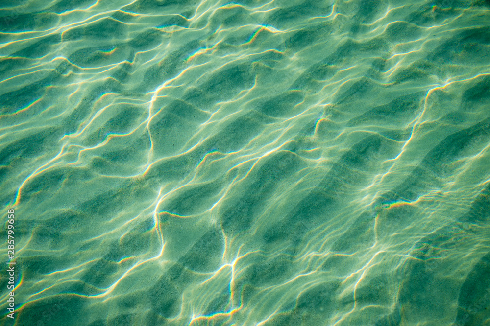 Tropical blue-green waters background in shallow seas with small waves in bright sunlight Tropical blue-green waters background in shallow seas with small waves in bright sunlight