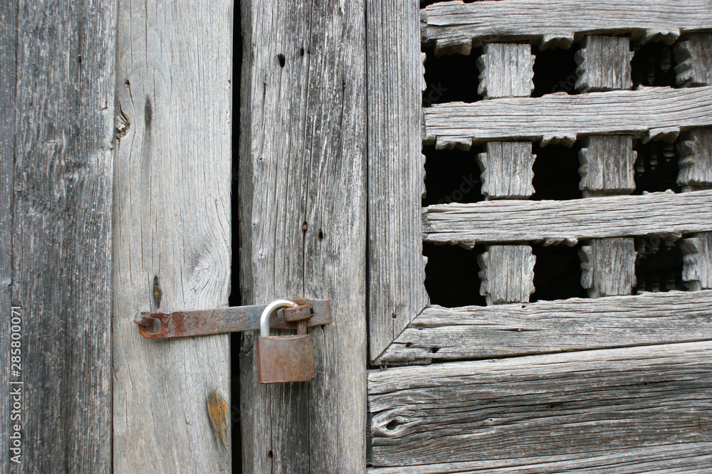 antique wooden window closed by an old rusty lock antique wooden window closed by an old rusty lock