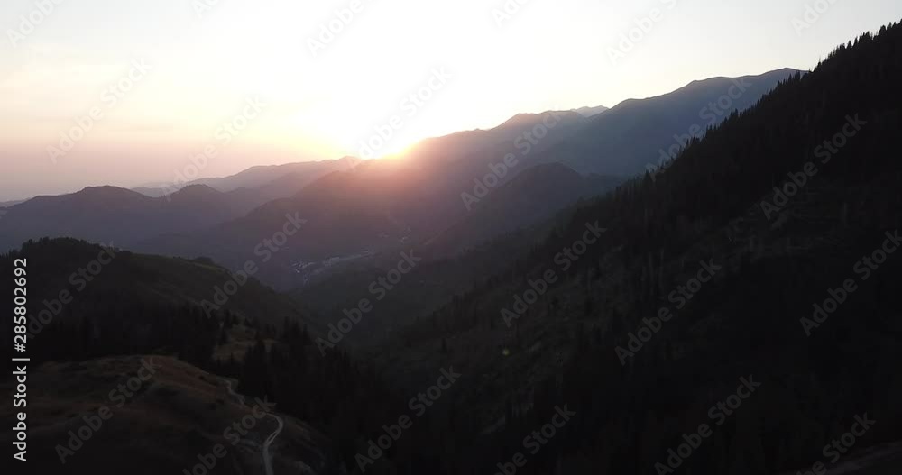 Red dawn in the mountains. Orange sky in the clouds. Fog over mountains and forests. The first rays of the sun come from behind the hills. Drone footage. Red dawn in the mountains. Orange sky in the clouds. Fog over mountains and forests. The first rays of the sun come from behind the hills. Drone footage.