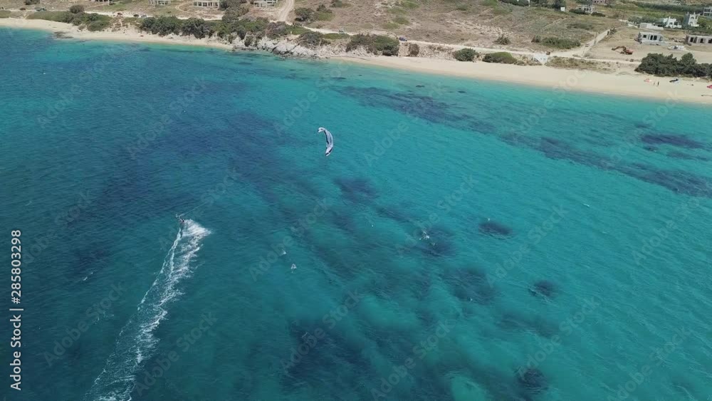 Luftaufnahme Kitesurfer fährt Richtung Küste in türkisfarbenem Wasser Luftaufnahme Kitesurfer fährt Richtung Küste in türkisfarbenem Wasser