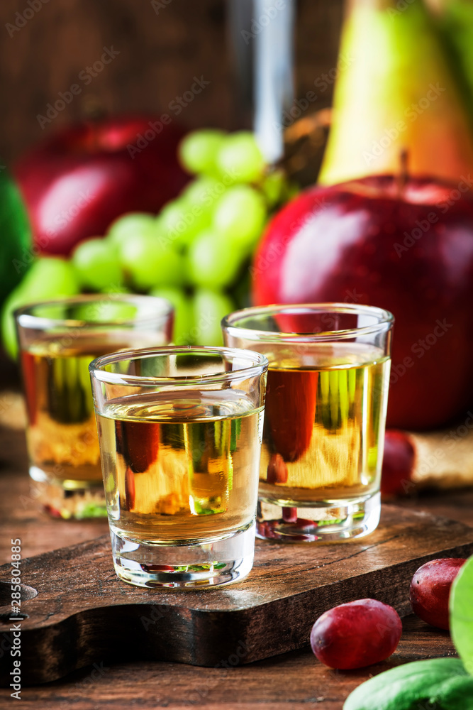 Rakija, raki or rakia - Balkan hard alcoholic drink or brandy from fermented fruits, old wooden table, still life, copy space Rakija, raki or rakia - Balkan hard alcoholic drink or brandy from fermented fruits, old wooden table, still life, copy space