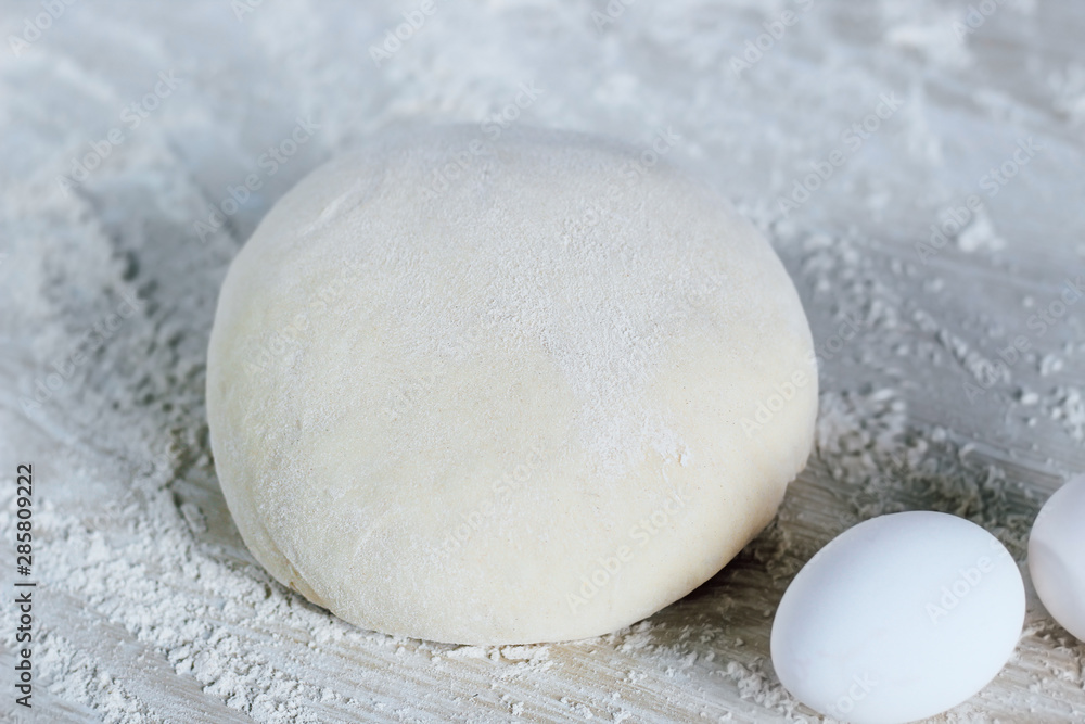 dough with flour and eggs on a white background; Dough ready for cooking dough with flour and eggs on a white background; Dough ready for cooking