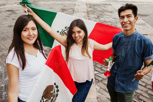 Mexican people cheering with flag of Mexico, Viva Mexico in Mexican independence day photo