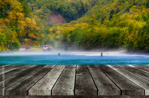 empty grey wooden table or wooden terrace with beautiful view of Taisho pond at Kamikochi National Park in the Northern Japan Alps of Nagano, Matsumoto, Japan, copy space for display product or object © Vittaya_25
