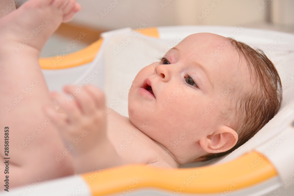 Pretty three months baby girl taking a bath by her mother at home, european child. Pretty three months baby girl taking a bath by her mother at home, european child.