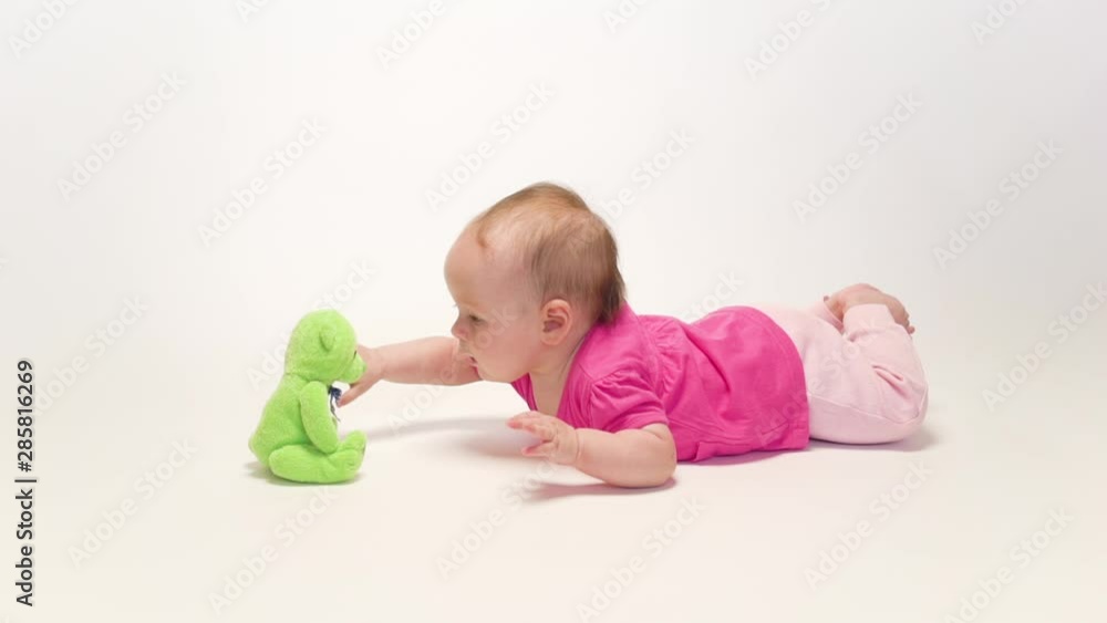 Cute baby girl playing with soft toy on white background Cute baby girl playing with soft toy on white background
