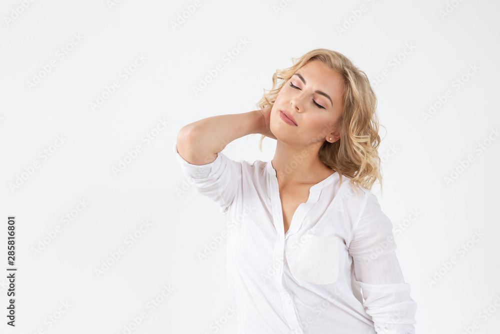 Smiling charming young blonde woman standing against a white background with copy space. Concept of carefree young girl Smiling charming young blonde woman standing against a white background with copy space. Concept of carefree young girl