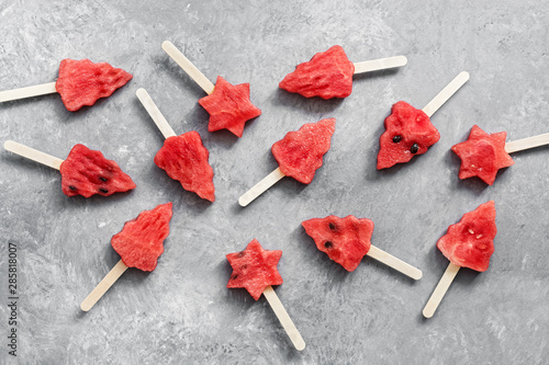 Watermelon ice cream in the shape of a Christmas tree. Summer fruit dessert on a stick. Top view, flat lay