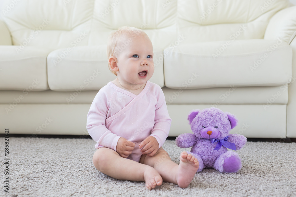 Cute little baby girl wearing pink clothes sitting on carpet Cute little baby girl wearing pink clothes sitting on carpet