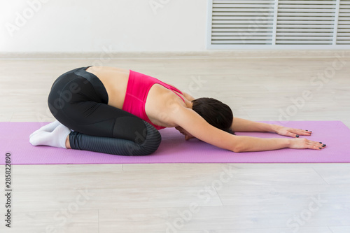 young woman doing stretching fitness exercise at yoga