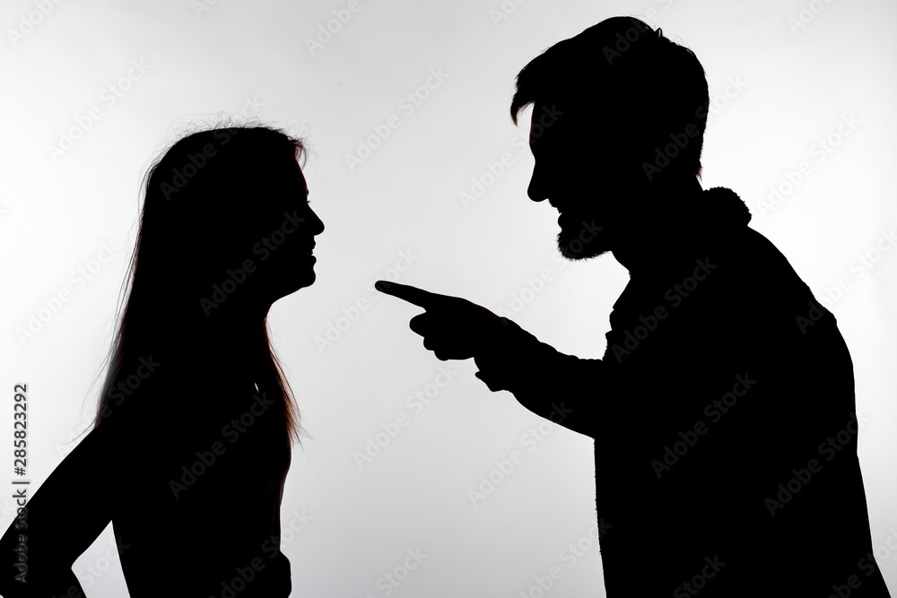 Relationship difficulties, conflict and abuse concept - man and woman face to face screaming shouting each other dispute silhouette isolated on white background