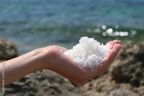 Female hand holding salt from the sea