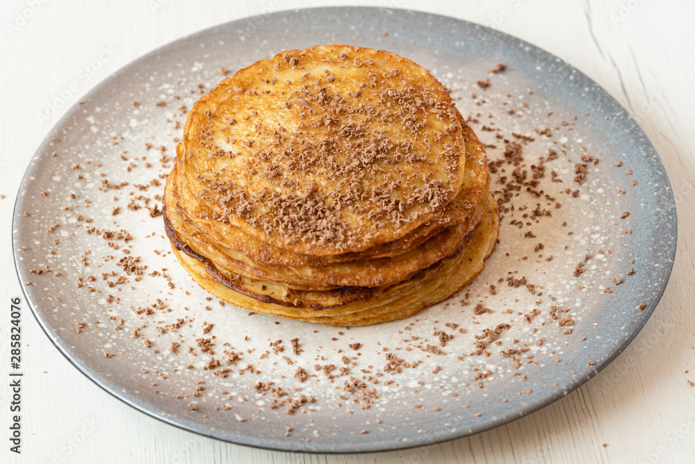 stack of American pancakes with chocolate in a gray plate on a wooden table. cooking concept.