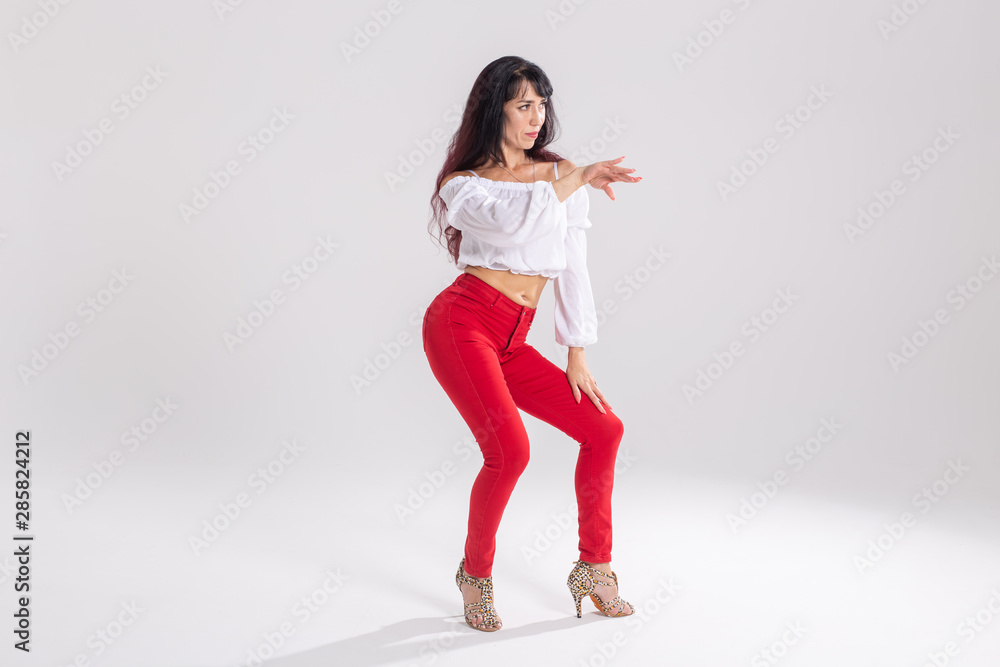 Latin dance, contemporary dance, bachata solo and cha-cha-cha concept - portrait of a young woman salsa dancer in a dance pose on white background with copy space
