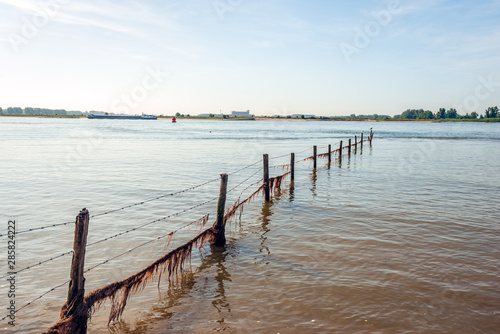 Fence with barbed wire into the river