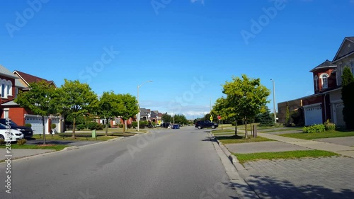 Viewpoint of Man Walking His Dog at City Suburb Four-Way Stop Sign Intersection Road With Traffic in Day.  Dog Walker Person at All-Way Stop Intersection Street.