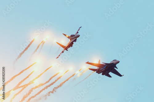 Two combat fighters jet perform an air battle with the firing of warheads with explosions.