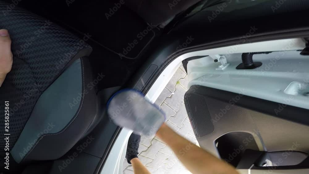 POV man wipes the back doorway of his automobile with a car wash mitt at a self-service car wash POV man wipes the back doorway of his automobile with a car wash mitt at a self-service car wash