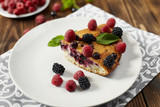 Piece of pie with blueberries on a plate, napkin on a wooden boards background