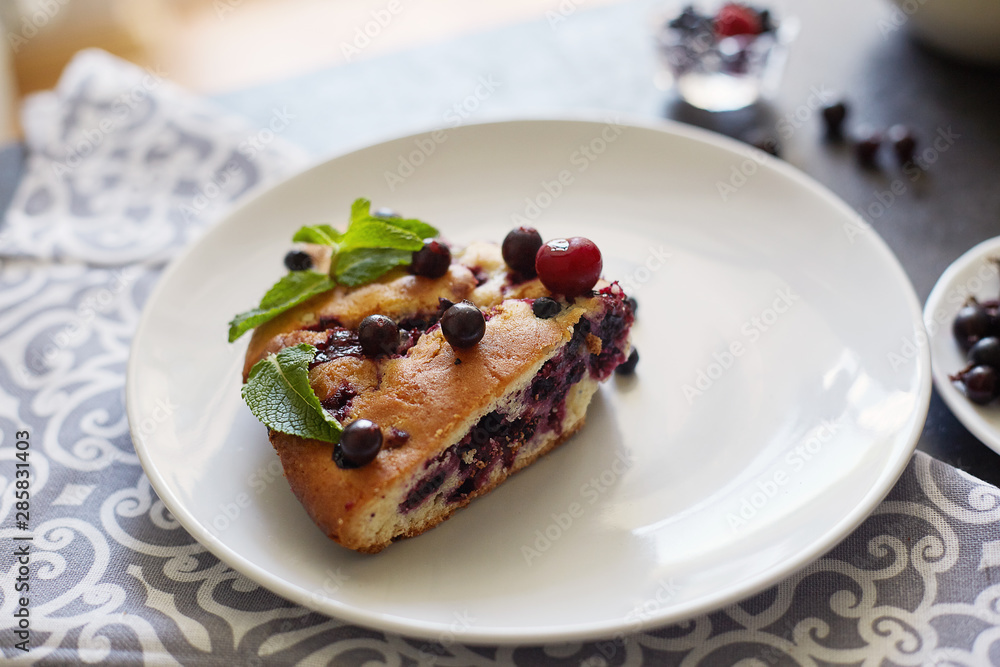 Piece of pie with blueberries, rasberry and mint for dessert on a white plate, napkin. Pieces of delicious homemade cake Piece of pie with blueberries, rasberry and mint for dessert on a white plate, napkin. Pieces of delicious homemade cake