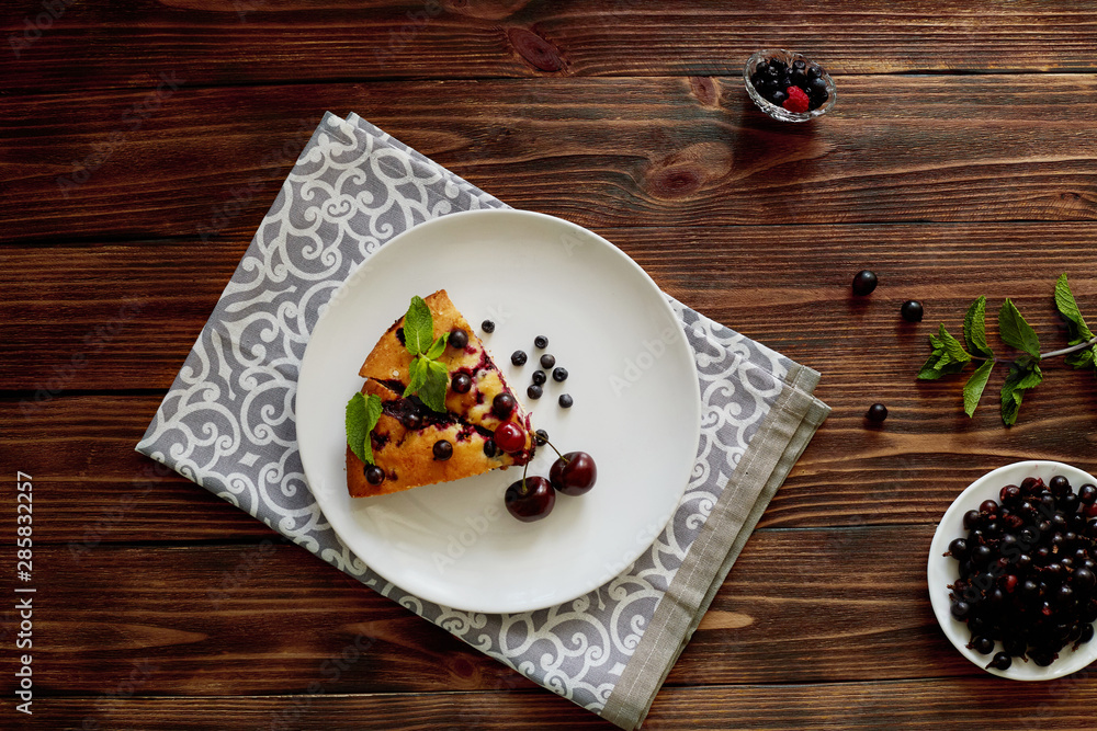 Piece of pie with blueberries, rasberry,cherries and mint for dessert on a white plate, napkin. Pieces of delicious homemade cake Piece of pie with blueberries, rasberry,cherries and mint for dessert on a white plate, napkin. Pieces of delicious homemade cake
