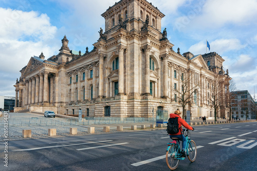 Lady on bicycle at Reichstag building with German Flags Berlin