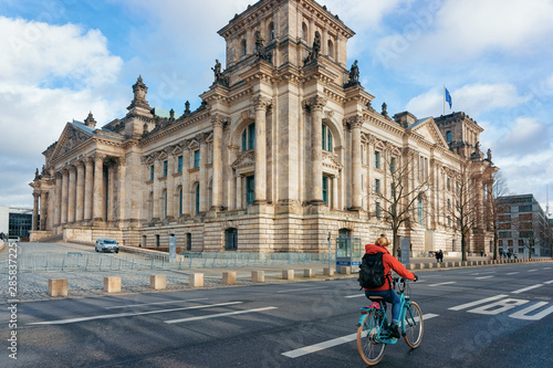 Lady on bicycle Reichstag building with German Flags Berlin