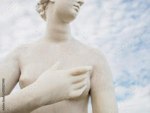 Female sculpture, fragment. Close-up of female hand covers breast, concept of female breast health problems