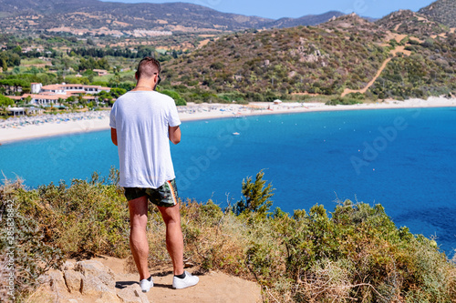 Fototapeta Naklejka Na Ścianę i Meble -  Man looking at beach near Mediterranean Sea in Villasimius Cagliari