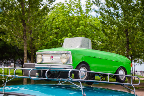 A small Soviet children's car on the trunk of a large car