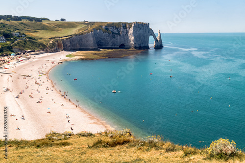 Aerial panoramic view of Etretat coastline with white chalk cliffs, Aiguille d'Etretat, natural stone arch and the beach. Etretat, Normandy, France.  photo