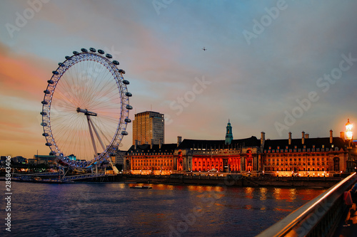 London Eye Ferris Wheel and County Hall in London dusk