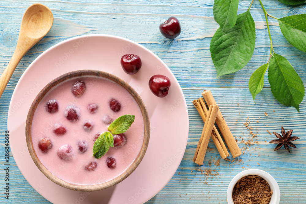 Flat lay of meglevesh, hungarian cold cherry soup, served in wooden bowl