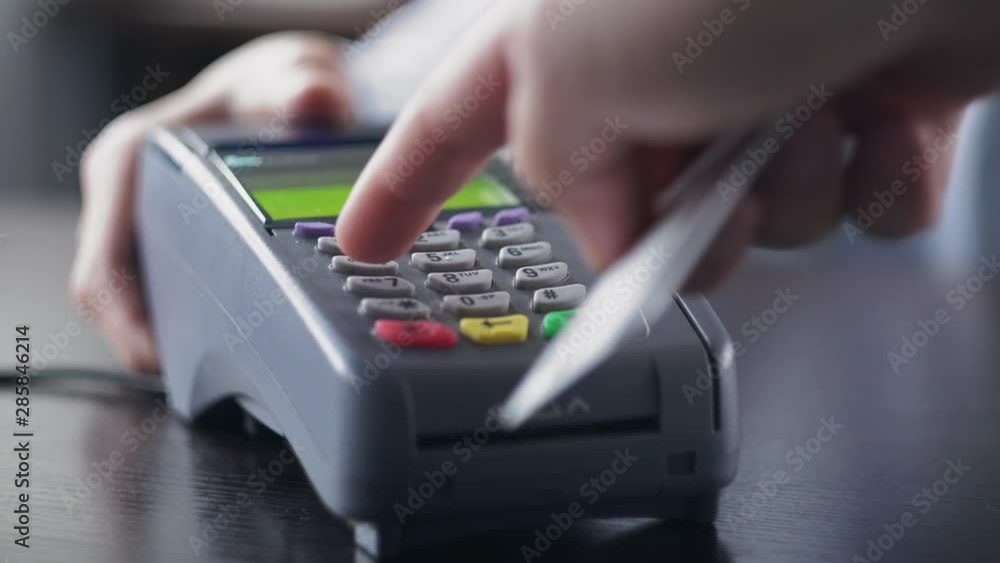 Man hand with credit card swipe through pos terminal and enter pin code. Banking services of electronic money, making transaction Man hand with credit card swipe through pos terminal and enter pin code. Banking services of electronic money, making transaction
