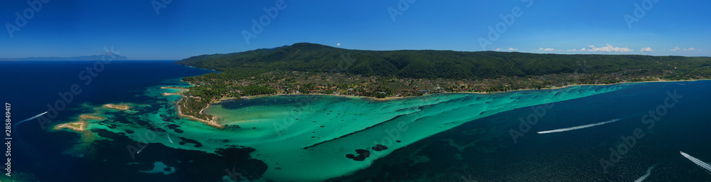 Aerial drone panoramic photo of iconic bay with turquoise frozen waves of Vourvourou in Sithonia Peninsula, Halkidiki, North Greece