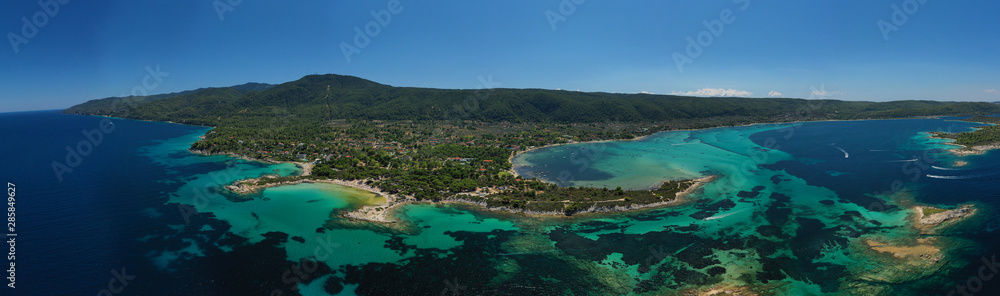 Aerial drone panoramic photo of iconic bay with turquoise frozen waves of Vourvourou in Sithonia Peninsula, Halkidiki, North Greece - obrazy, fototapety, plakaty 