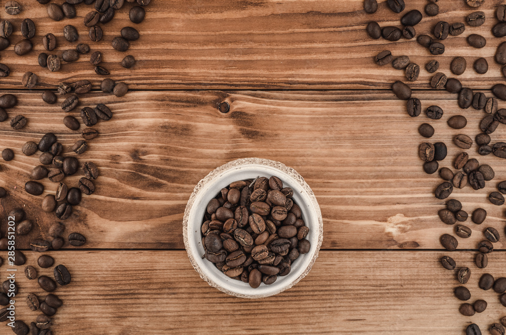 Coffee lines and beens in white pot on brown wooden background. Top view Coffee lines and beens in white pot on brown wooden background. Top view