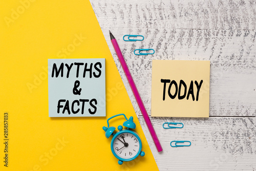 Word writing text Myths And Facts. Business photo showcasing usually traditional story of ostensibly historical events Notepads marker pen colored paper sheet alarm clock wooden background photo