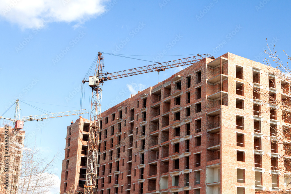 High-rise multi-storey buildings under construction. Tower cranes near building. Activity, architecture, development process, skyscraper High-rise multi-storey buildings under construction. Tower cranes near building. Activity, architecture, development process, skyscraper
