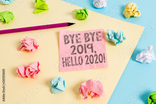 Conceptual hand writing showing Bye Bye 2019 Hello 2020. Concept meaning saying goodbye to last year and welcoming another good one Colored crumpled papers empty reminder blue yellow clothespin © Artur