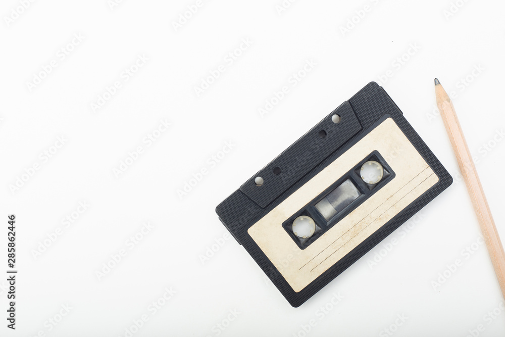 Fototapeta premium old audio cassette and pencil on white background