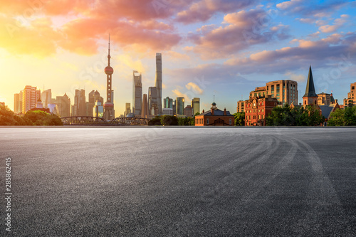 Empty race track and modern city scenery at sunrise in Shanghai,China.