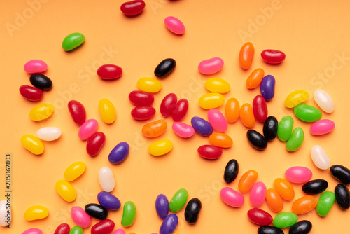 Fototapeta Naklejka Na Ścianę i Meble -  colourful jelly beans candies orange background Top view