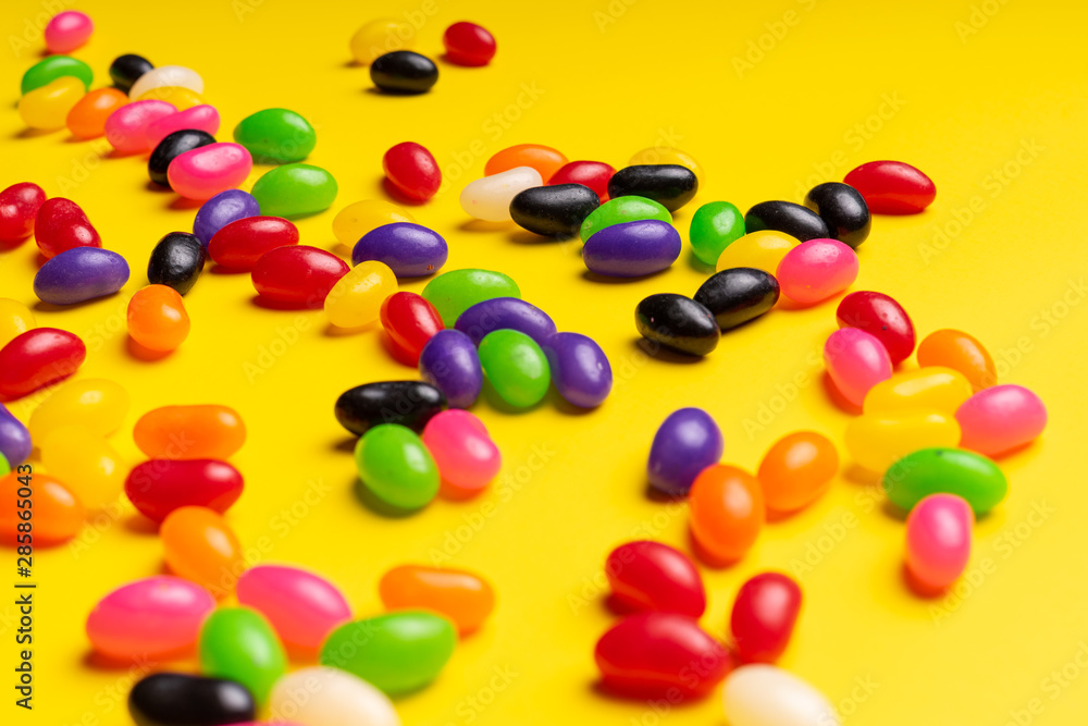 colourful jelly beans candies yellow background Top view colourful jelly beans candies yellow background Top view