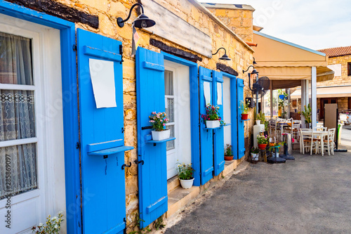 Island of Cyprus. The Village Of Kouklia. Picturesque street Kouklia. Street with blue shutters and flowers. Rural landscape. One-storey buildings. Travelling to Cyprus.