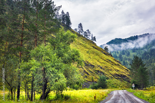 Dirt road surrounded by mountains. Gorny Altai, Siberia, Russia photo