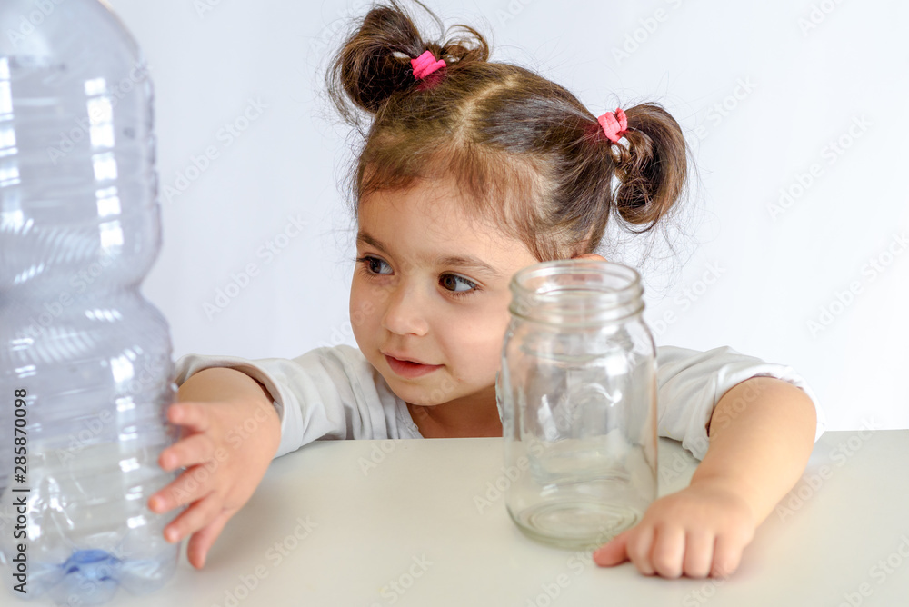 Child pushing the plastic bottle, holding glass jar. No to Plastic Containers, Yes to Glass Jars. Conceptual image for anti plastic campaign. Child pushing the plastic bottle, holding glass jar. No to Plastic Containers, Yes to Glass Jars. Conceptual image for anti plastic campaign.