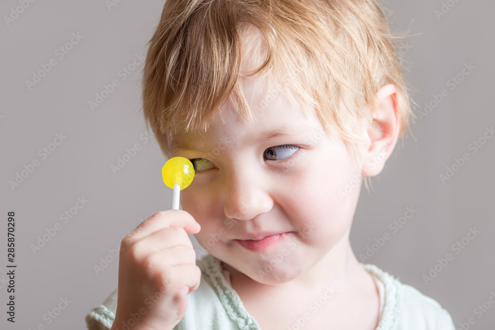 Cute baby with yellow candy in his hands. Cute baby with yellow candy in his hands.